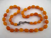 Appraisal: An amber bead necklace with a white metal tests silver