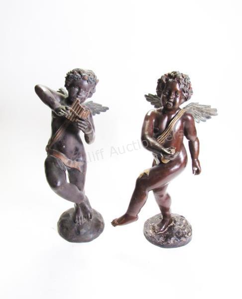 Appraisal: A pair of bronze cherub garden figures one playing horn