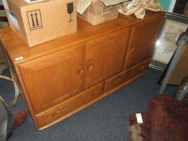 Appraisal: A light elm Ercol side cabinet with three cupboard doors