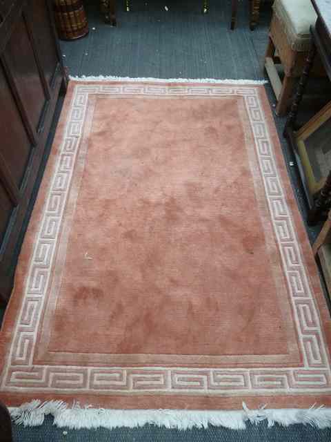 Appraisal: TWO APRICOT GROUND RUGS with Greek key borders one x