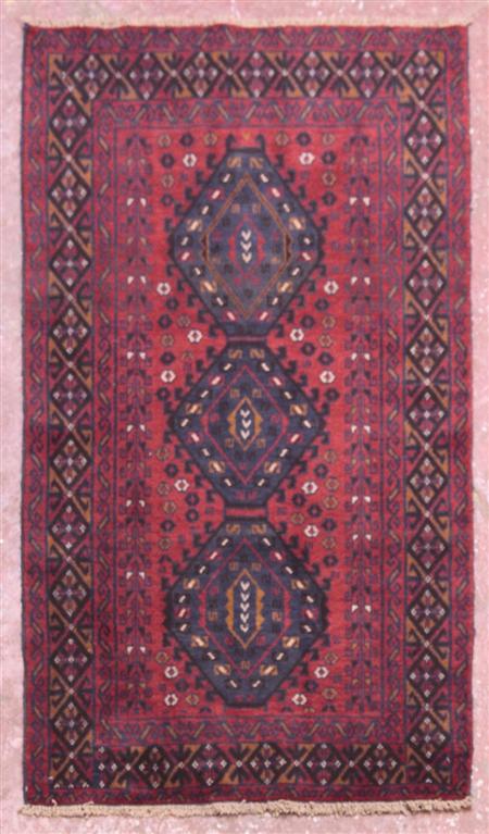 Appraisal: A Belouch rug the red field with three indigo hooked