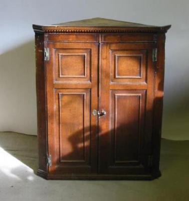 Appraisal: A GEORGE III OAK CORNER CUPBOARD the dentil moulded cornice