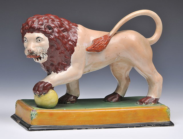 Appraisal: A STAFFORDSHIRE POLYCHROME MODEL OF A LION on a rectangular