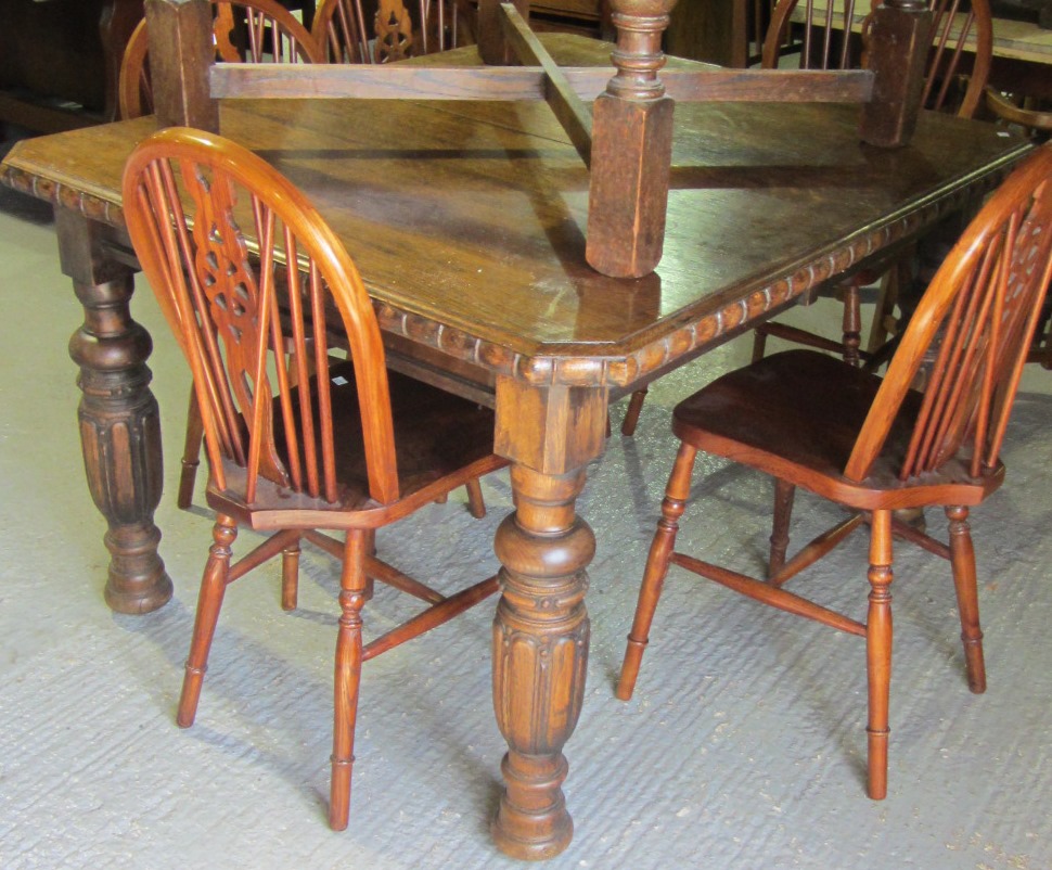 Appraisal: A carved oak extending dining table with one extra leaf