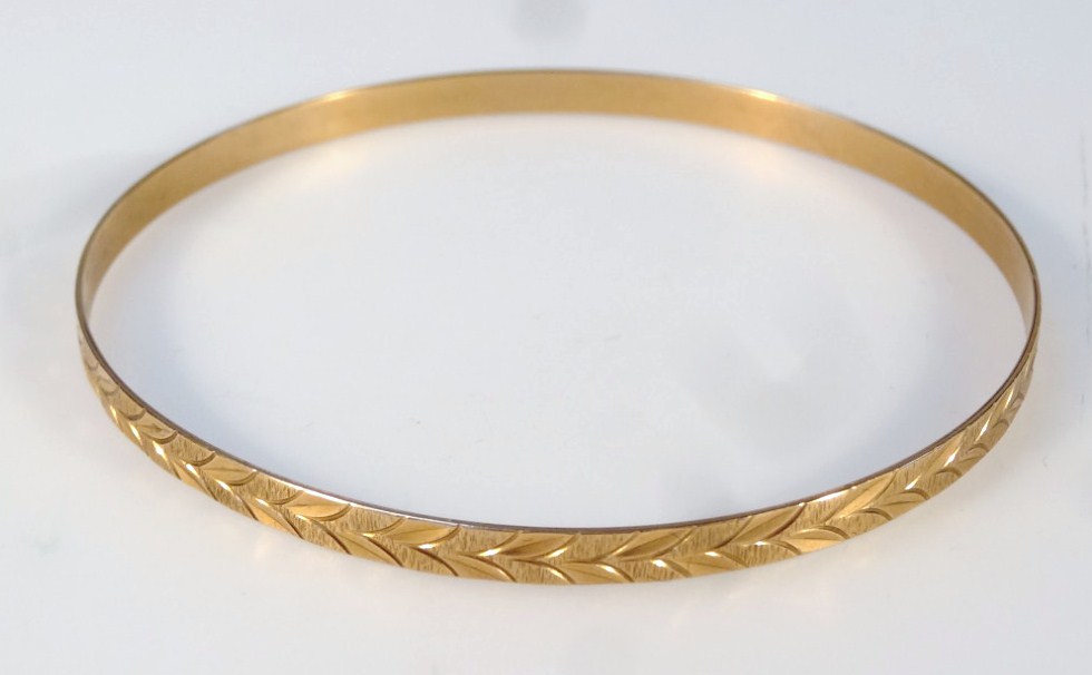 Appraisal: A bangle with an outer floral textured rim marked g