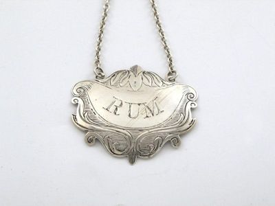 Appraisal: A Victorian cartouche wine label engraved scroll decoration incised 'RUM'