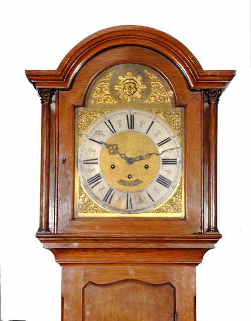 Appraisal: AN OAK LONG CASE CLOCK the break arch brass dial