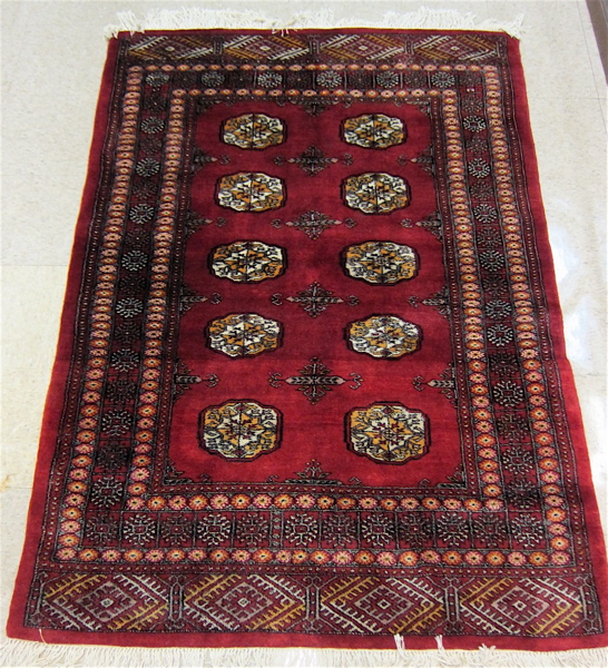 Appraisal: RED FIELD BOKHARA AREA RUG Pakistani made traditional Turkoman gol