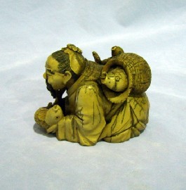 Appraisal: A carved figural ivory group of a crouching fisherman with