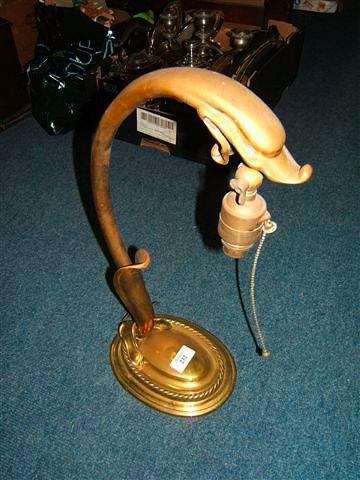 Appraisal: A brass table lamp with oval base and scrolling support