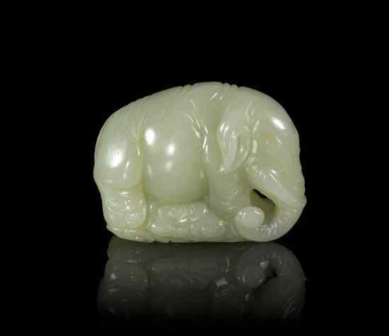 Appraisal: A Carved Jadeite Elephant the figure depicted on scrolling clouds