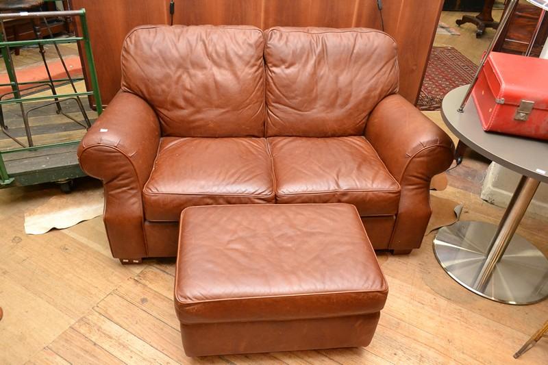 Appraisal: A MORAN TAN LEATHER UPHOLSTERED TWO SEAT SOFA WITH OTTOMAN