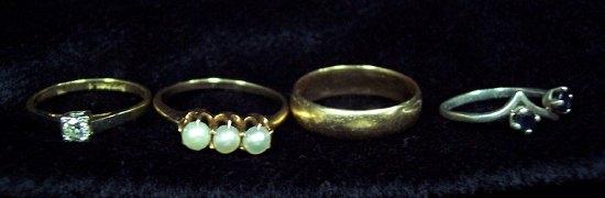 Appraisal: A wedding band and three dress rings