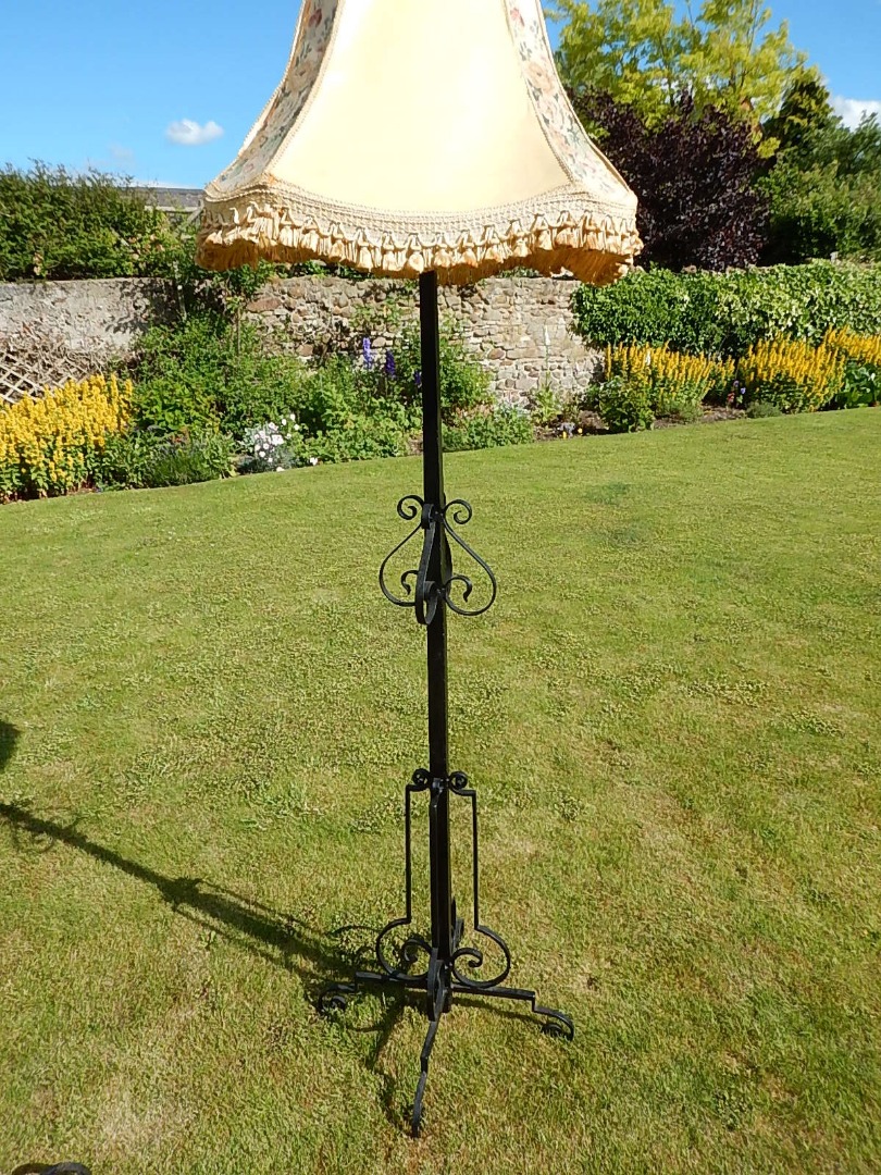 Appraisal: A wrought iron standard lamp with square section column scroll