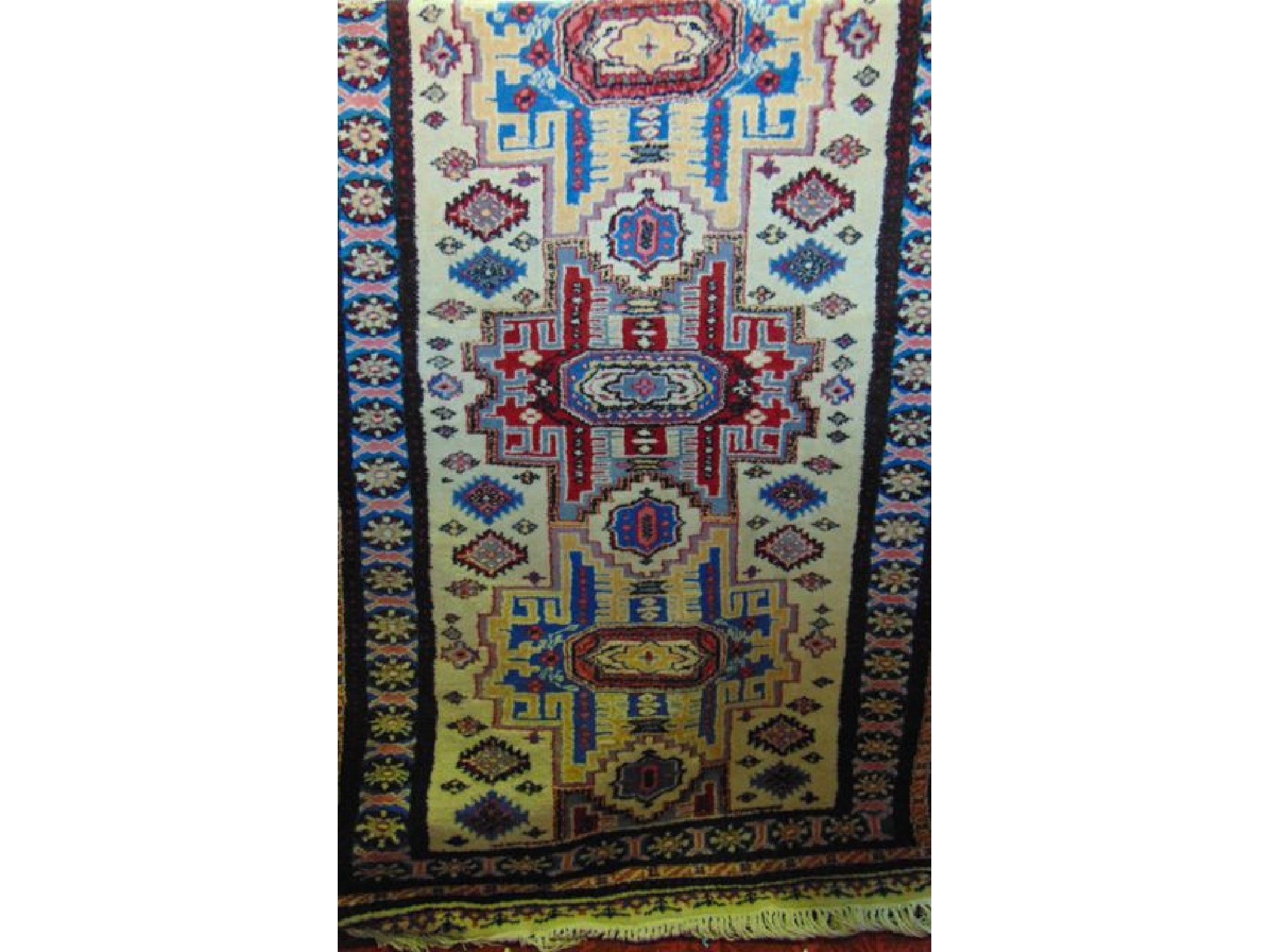 Appraisal: An eastern wool work rug with multi medallion geometric detail