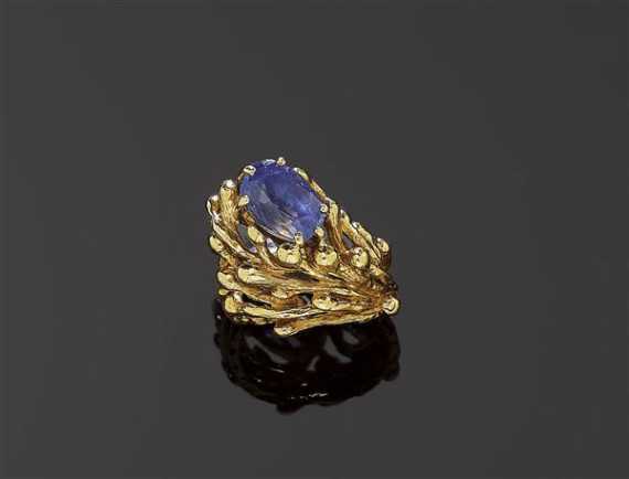 Appraisal: SAPPHIRE AND GOLD RING GILBERT ALBERT Yellow gold Decorative textured