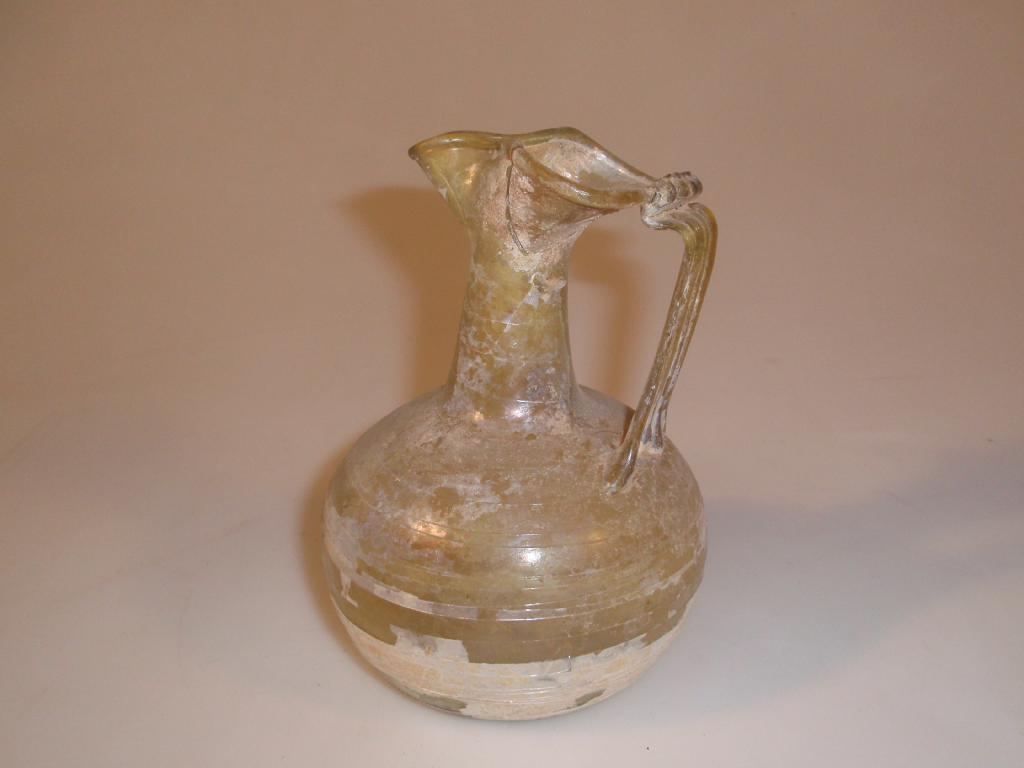 Appraisal: A late Roman light olive-green glass jug the trefoil mouth