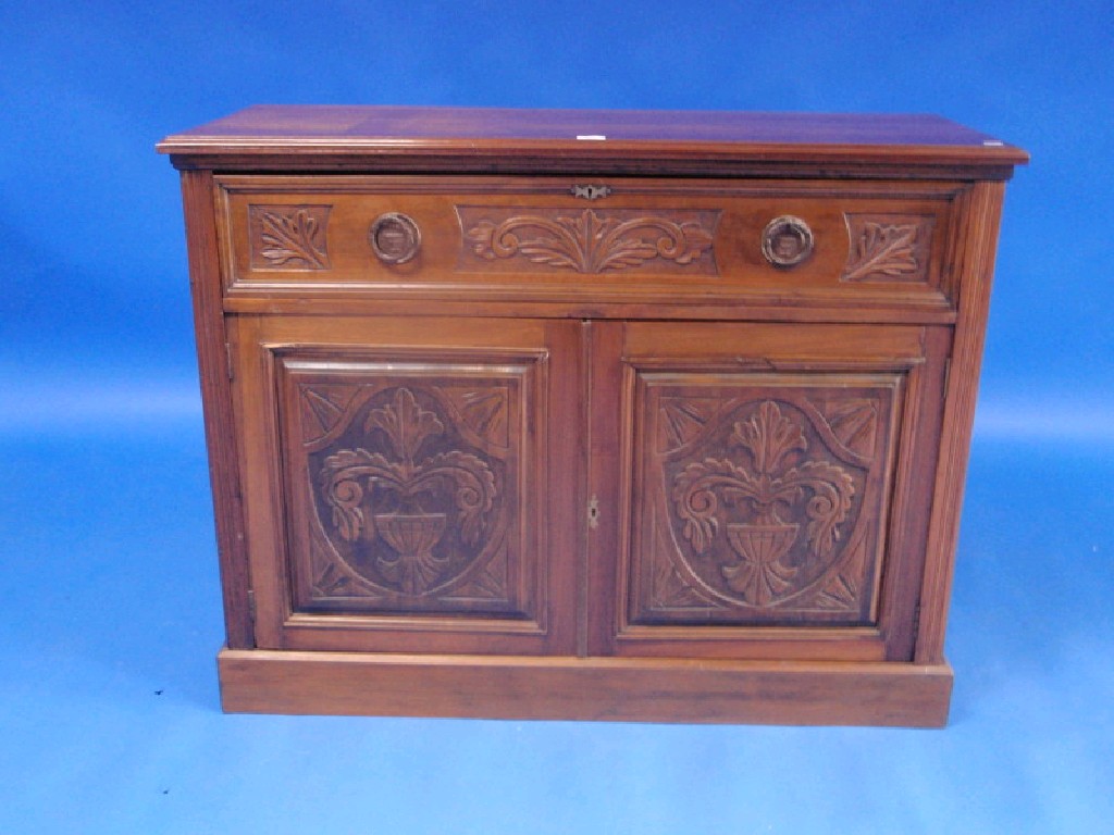 Appraisal: A late Victorian carved walnut secretaire with fitted drawer over