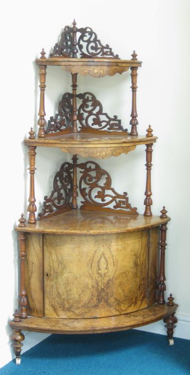 Appraisal: A Victorian walnut Corner Whatnot the base fitted cupboard with