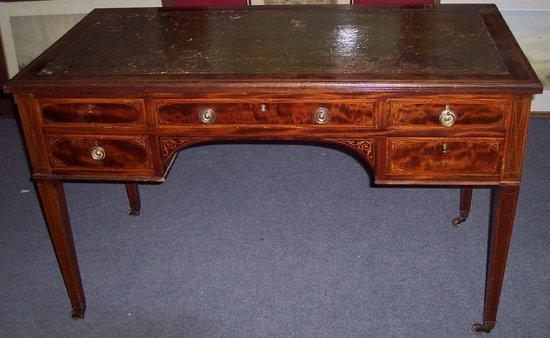 Appraisal: An Edwardian mahogany kneehole desk crossbanded in satinwood and fitted