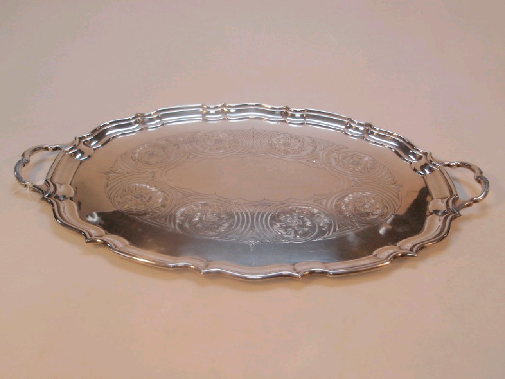 Appraisal: An electroplated oval serving tray with everted rim and two