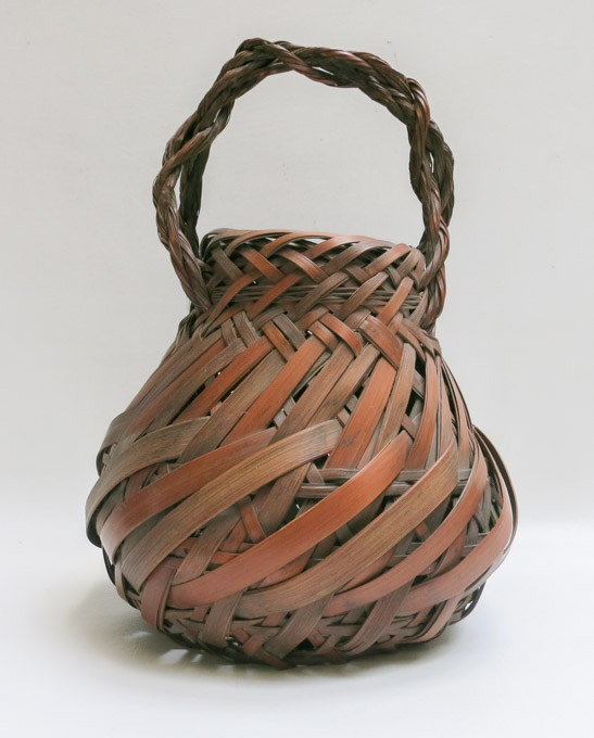 Appraisal: IKEBANA BASKET with bulbous body and braided arching handle height