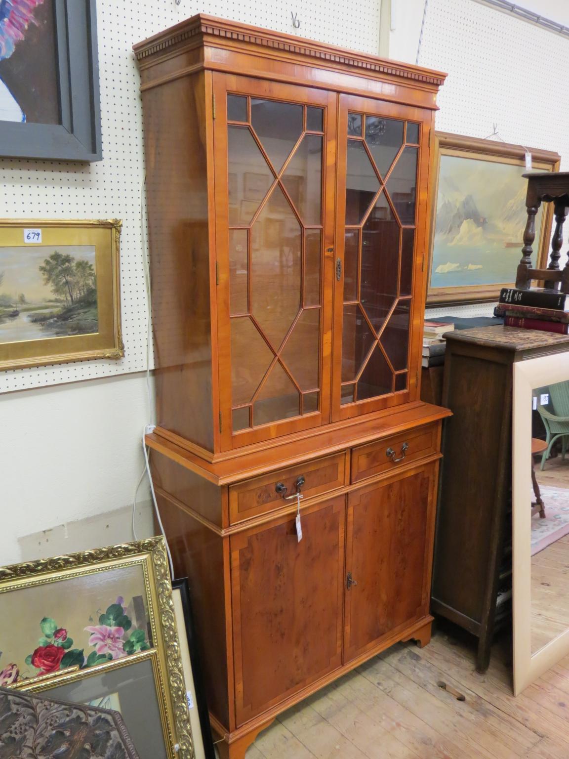 Appraisal: A reproduction yew-veneered tall bookcase pair of astragal-glazed doors enclosing