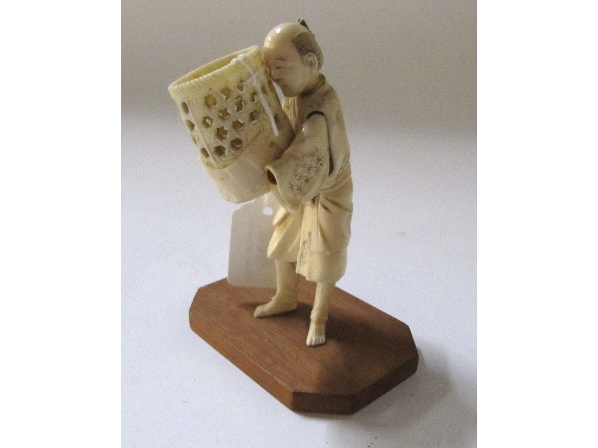 Appraisal: A Japanese carved ivory okimono man with basket some def