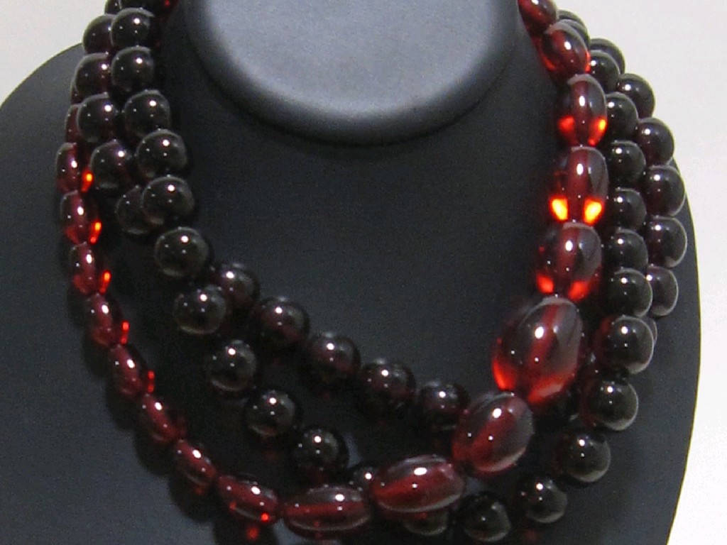 Appraisal: Three strings of amber coloured beads