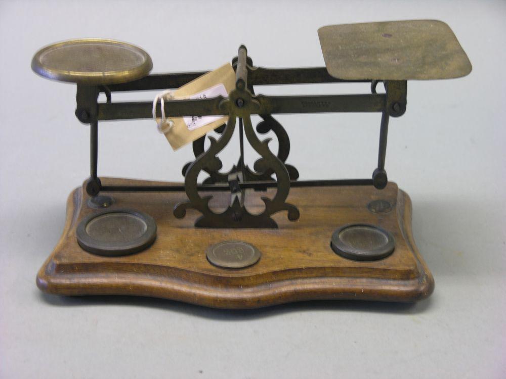 Appraisal: A Victorian-Edwardian postal scale brass frame on walnut plinth complete