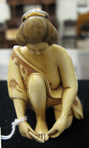 Appraisal: A JAPANESE IVORY FIGURE hand carved A woman seated partially