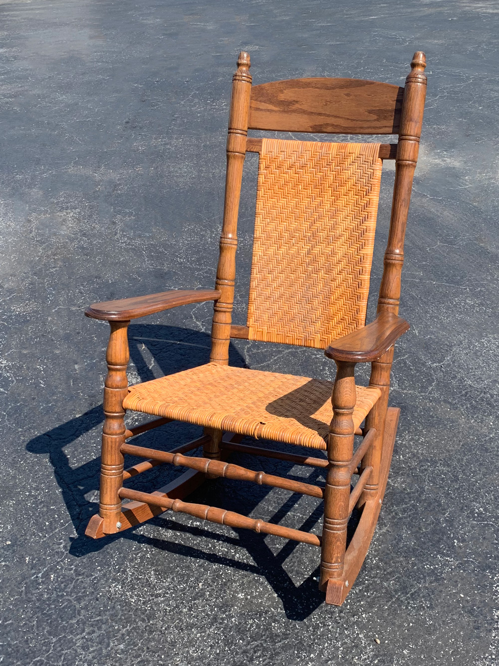 Appraisal: BRUMBY CANED PORCH ROCKING CHAIR Appalachian Red Oak construction signed