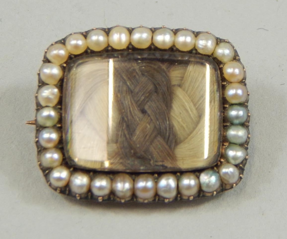 Appraisal: A Victorian memorial brooch with hair filled window inscribed back