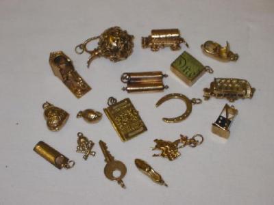 Appraisal: SEVENTEEN CT GOLD CHARMS including a Dewars bus a passport