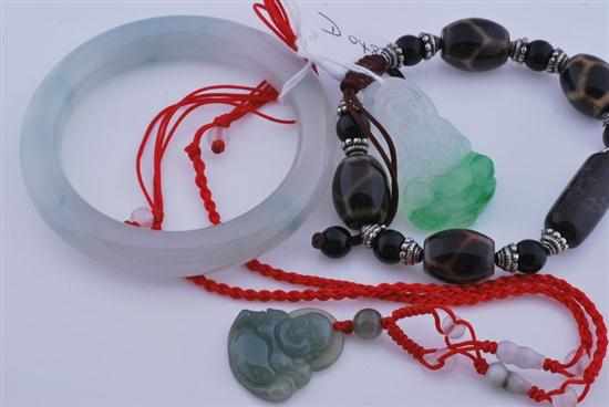 Appraisal: A JADE BANGLE AND TWO BUDDHA PENDANTS WITH A BROWN