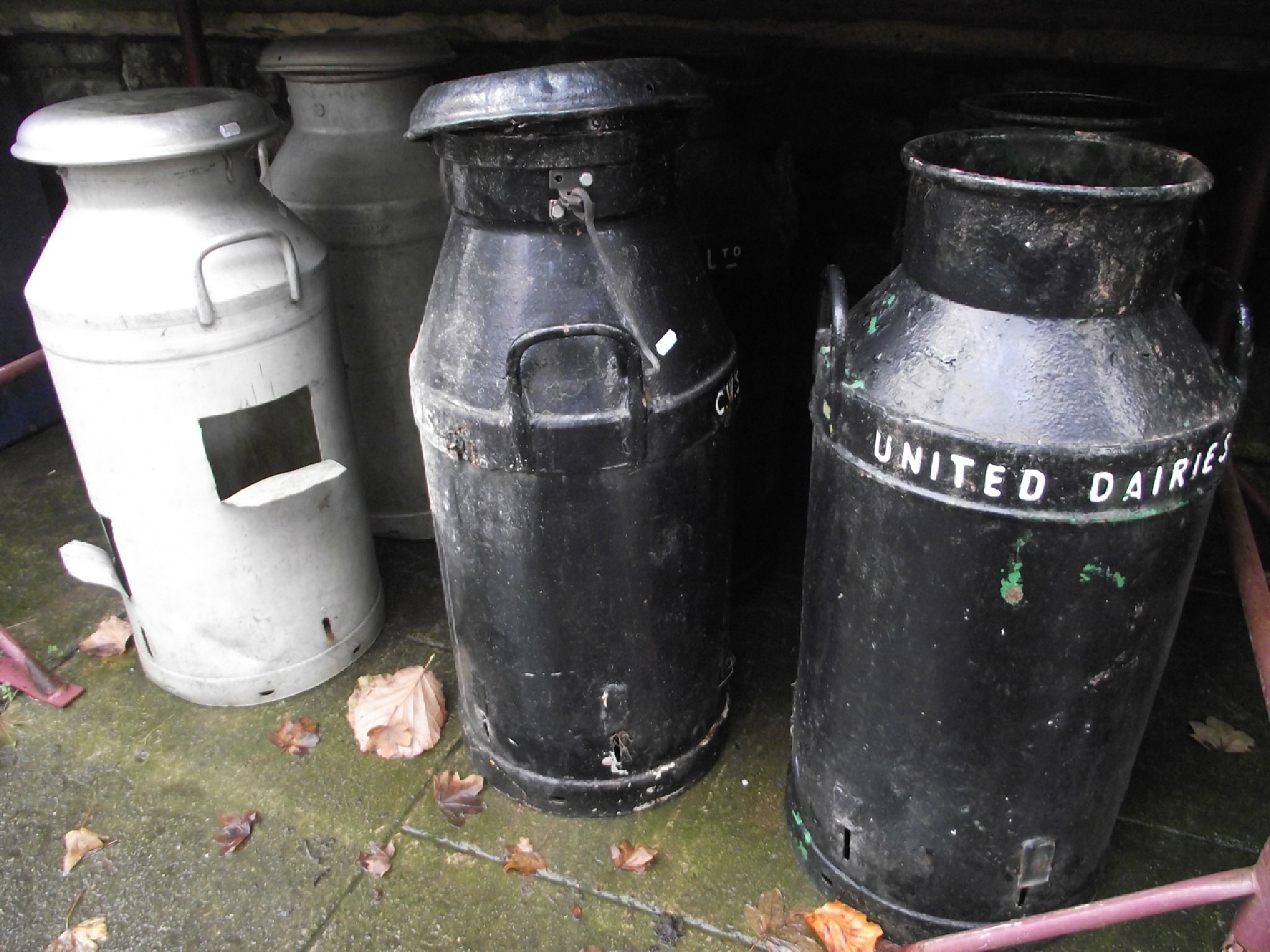 Appraisal: Four vintage cast iron two handled milk churns with later