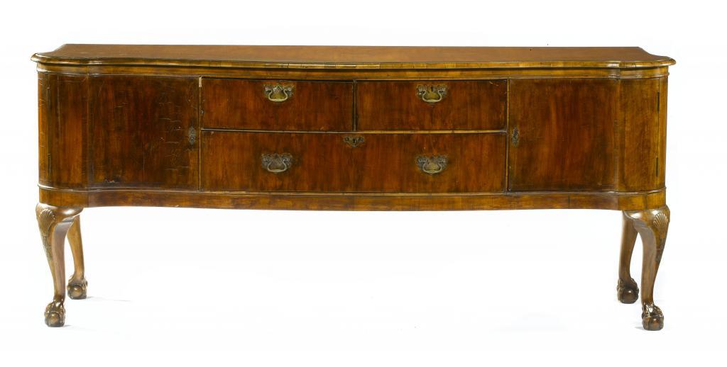 Appraisal: A WALNUT SERPENTINE SIDEBOARD with crossbanded top and fitted with