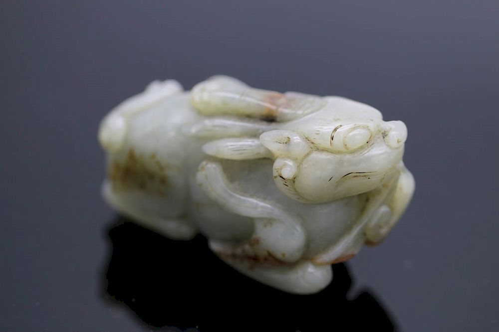 Appraisal: CELADON JADE MYSTICAL BEAST Depicting a recumbent mythical beast with