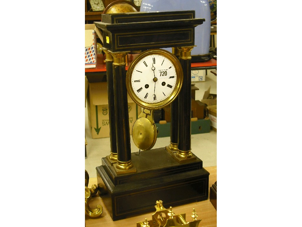 Appraisal: French ebonised two train portico clock the movement striking on