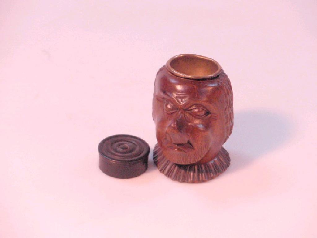 Appraisal: A carved treen head with brass inkwell receiver and a