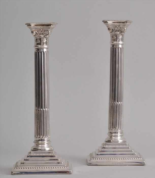 Appraisal: PAIR OF ENGLISH SILVER-PLATED COLUMN-FORM CANDLESTICKS Each stop-fluted stem with