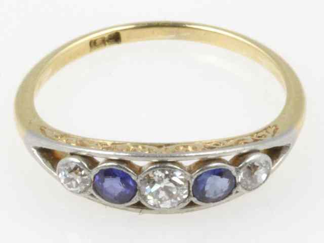 Appraisal: A sapphire and diamond five-stone ring in a pierced scroll