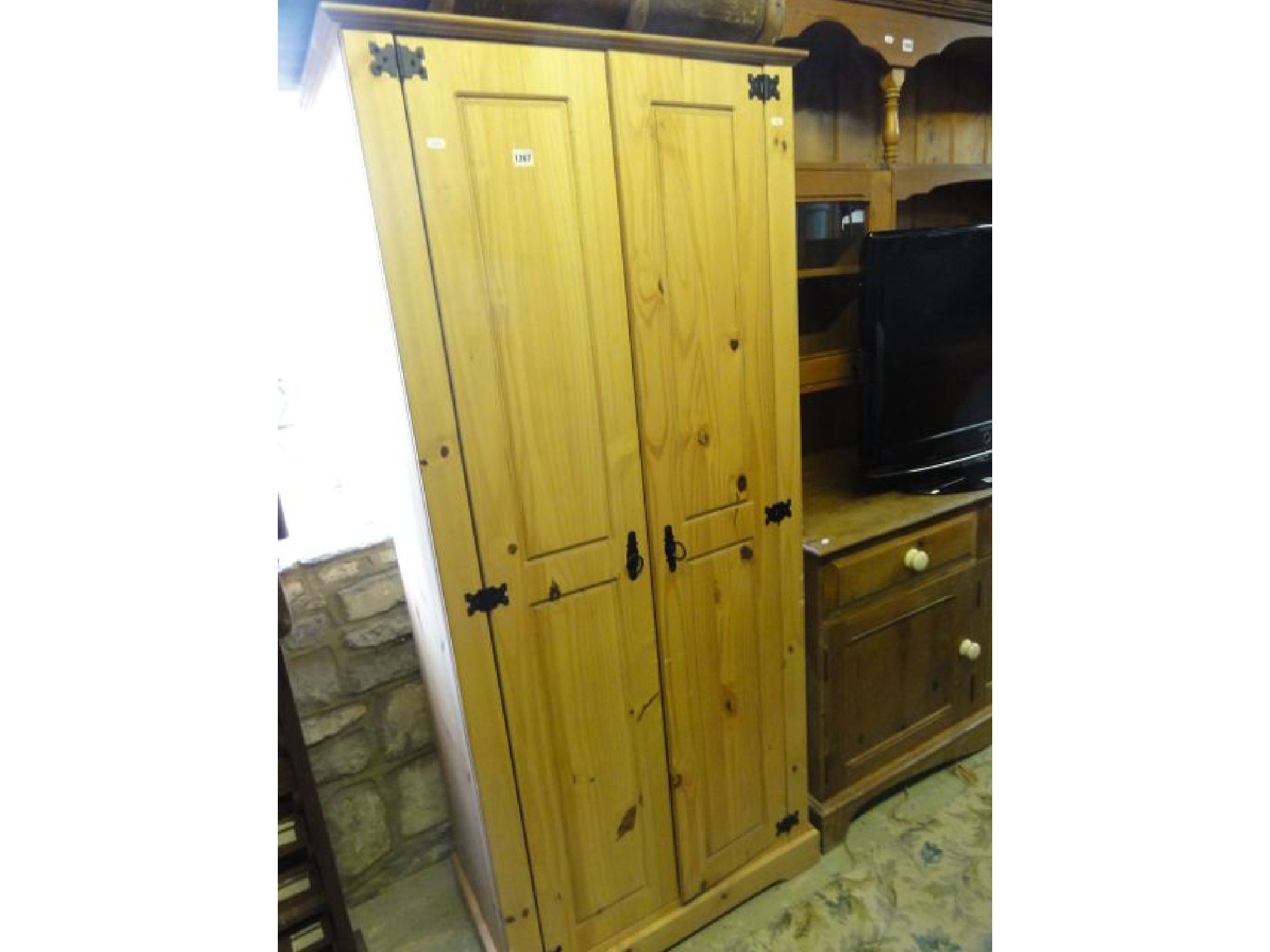 Appraisal: A small contemporary stripped pine wardrobe enclosed by a pair