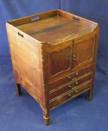 Appraisal: A George III oak pot cupboard the galleried top with