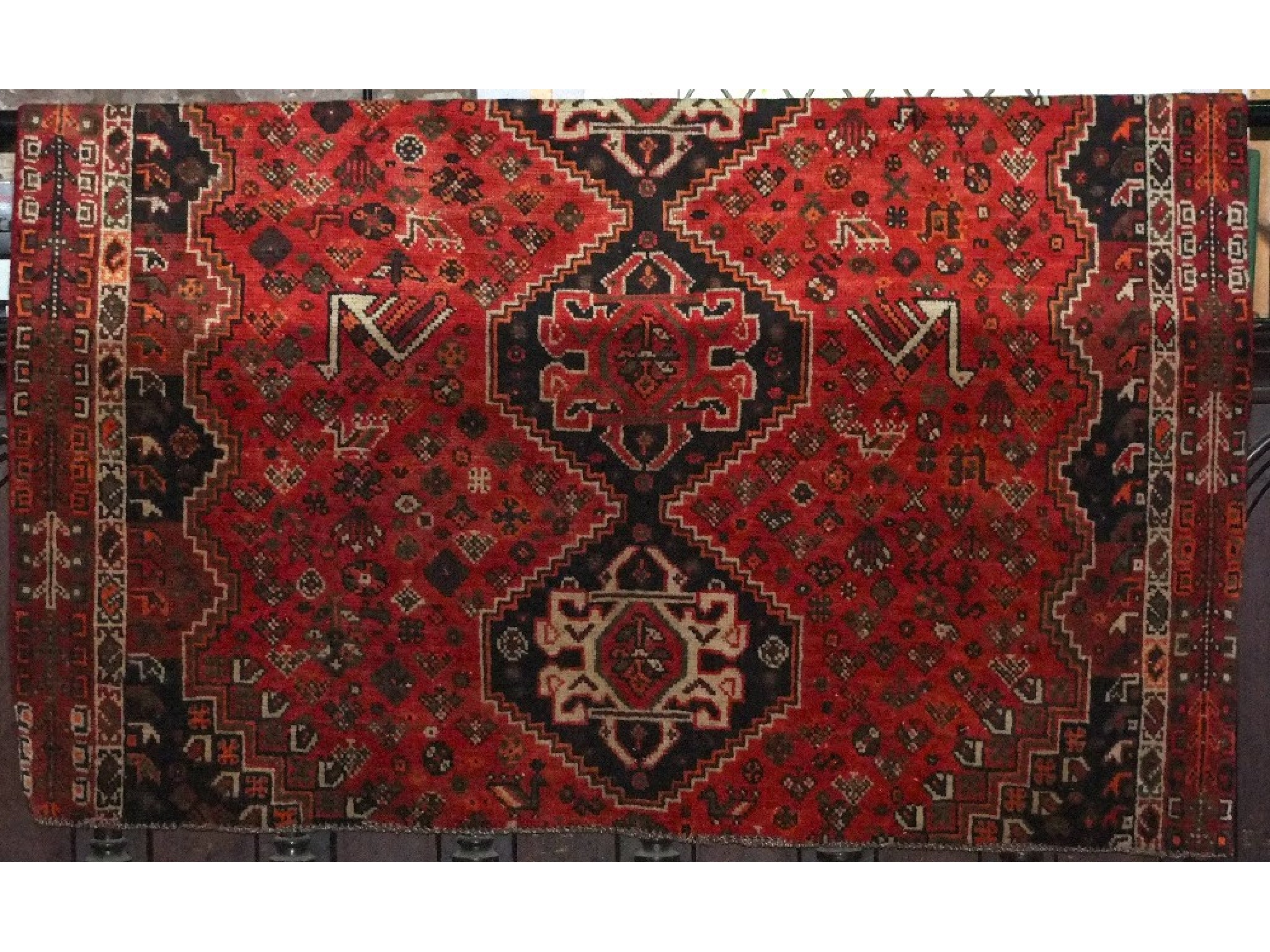 Appraisal: A Persian style carpet with red ground field central lozenge