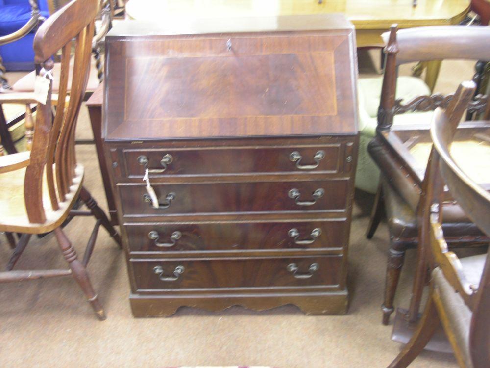 Appraisal: A reproduction mahogany bureau fall front enclosing an arrangement of