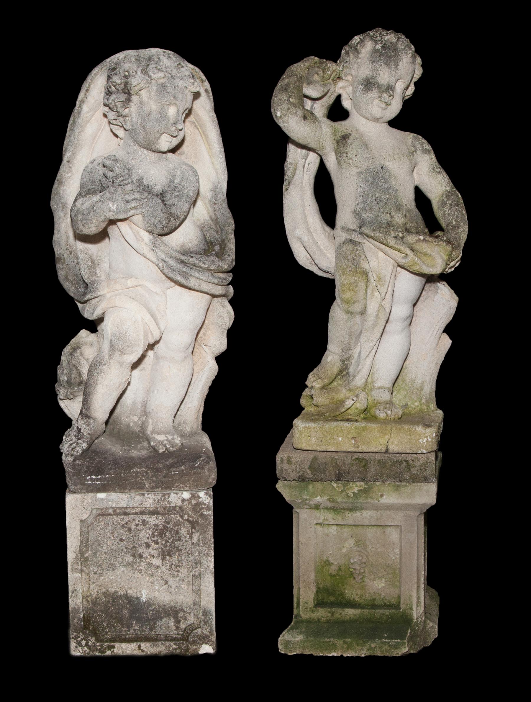 Appraisal: TWO CAST CONCRETE PUTTI GARDEN STATUES ON PLINTHS American nd