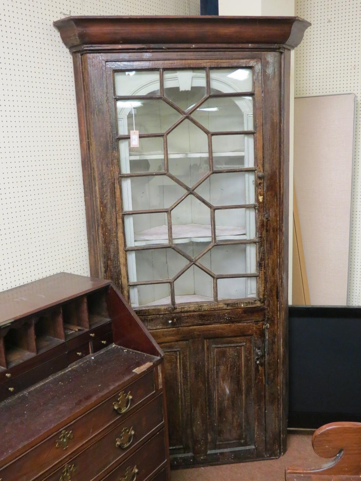 Appraisal: A Georgian stained pine standing corner cabinet astragal-glazed single door