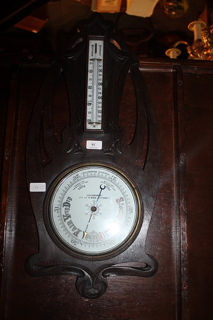 Appraisal: AN ART NOUVEAU OAK CASED ANEROID BAROMETER and thermometer retailed