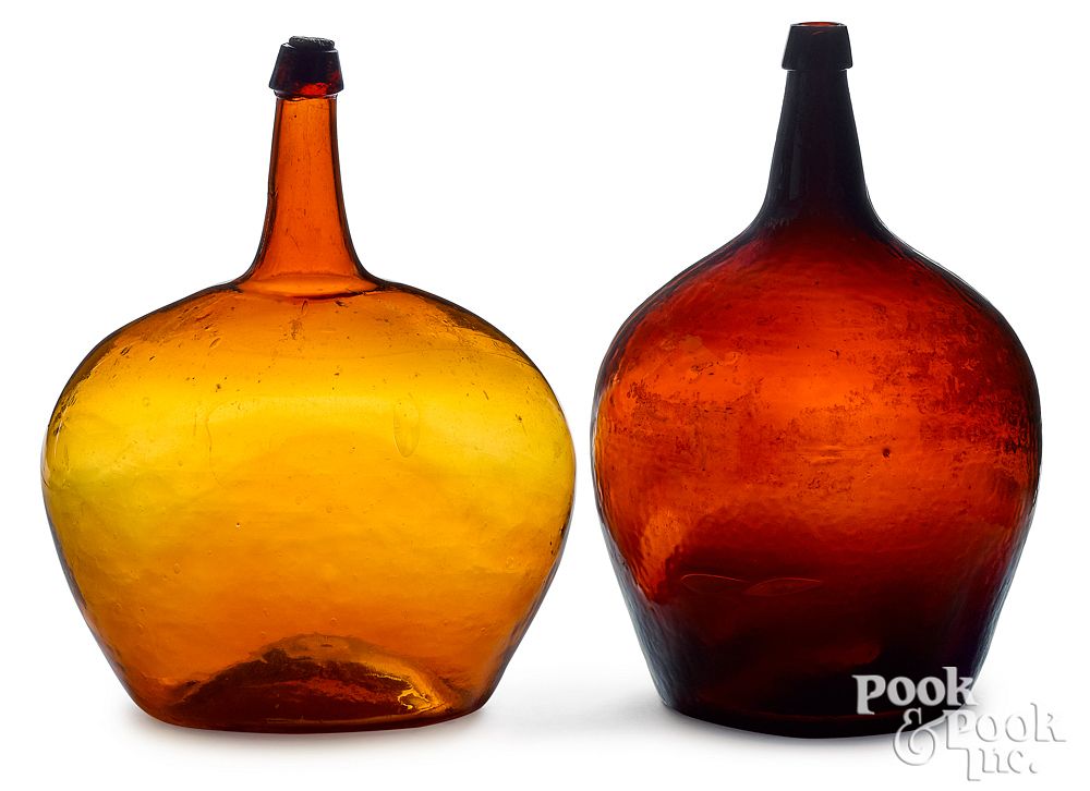 Appraisal: Two amber glass demijohns h Two amber glass demijohns h